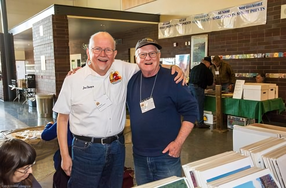 Two men smiling at a book fair.