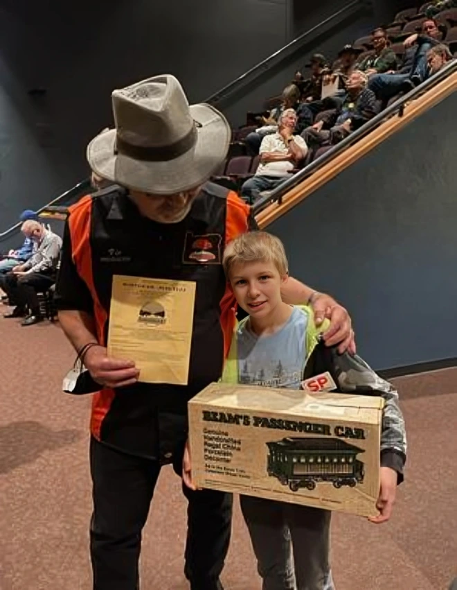 Man and boy holding a toy train box.